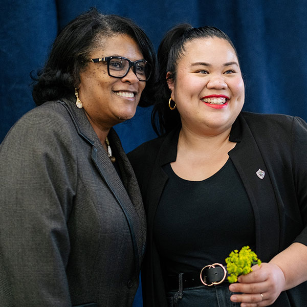 Student and faculty member smiling at recognition ceremony