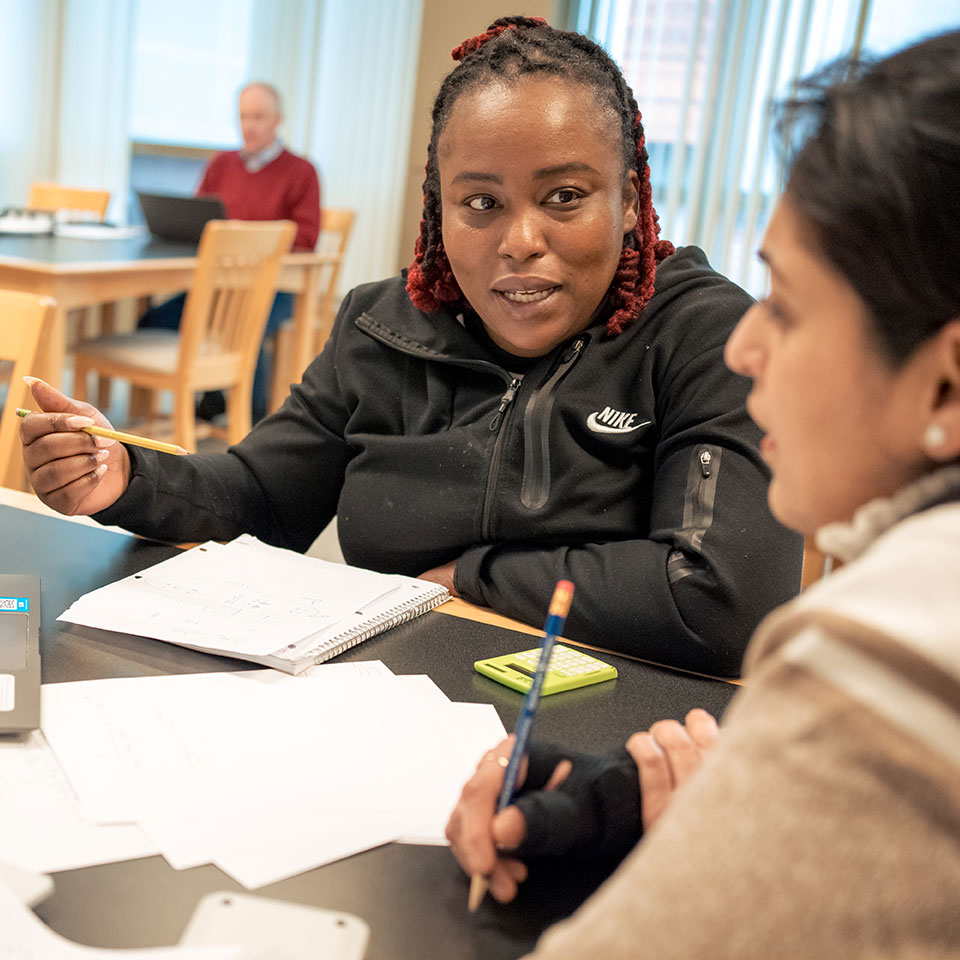 Two women sitting at table having a discussion