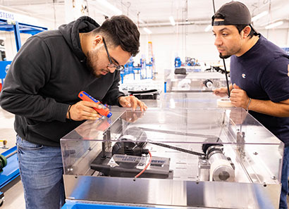 Two students working with equipment in the Advanced Technology Center