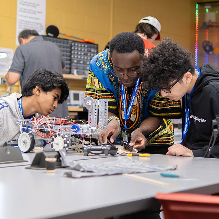 Two male students and instructor working on project in Baxter Innovation Lab