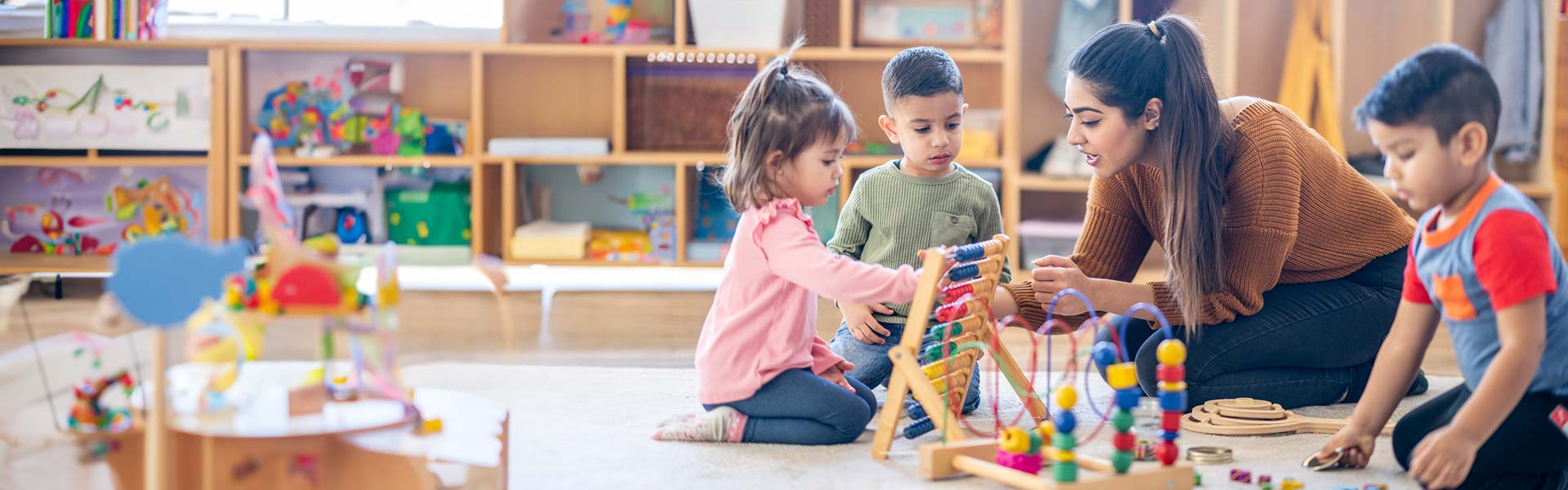 Female teacher teaching young students to use an abacus