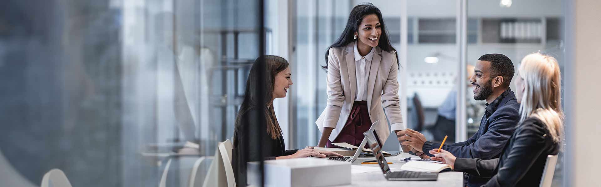 Four business people in a meeting laughing