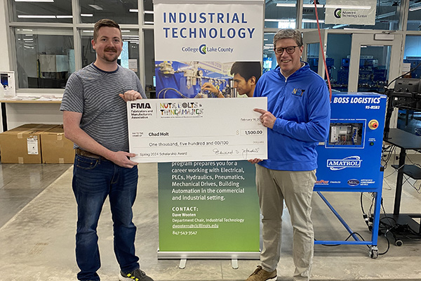 CLC student Chad Holt accepting a scholarship for manufacturing programs.