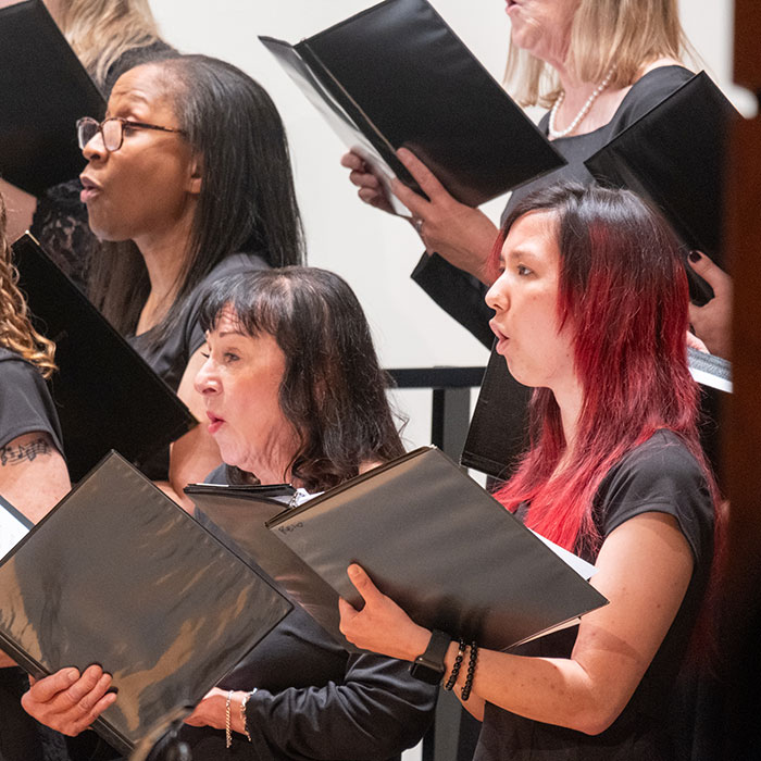 Female choir members singing during a performance