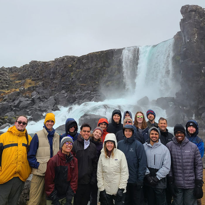 Small group standing in front of a waterfall