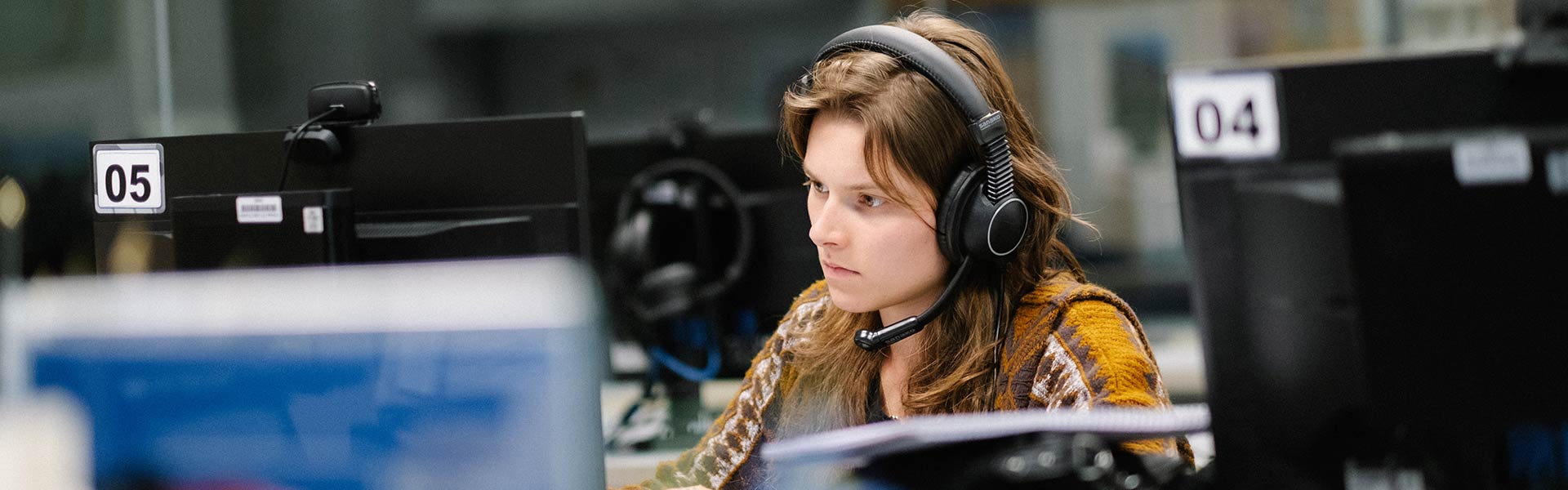 Student sits a computer with headphones working