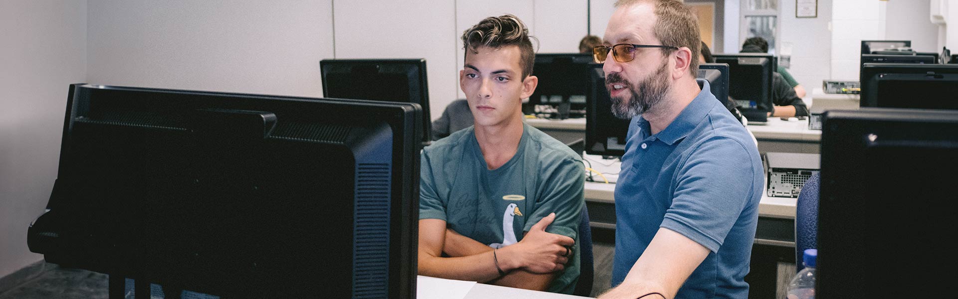 Two people looking at one computer