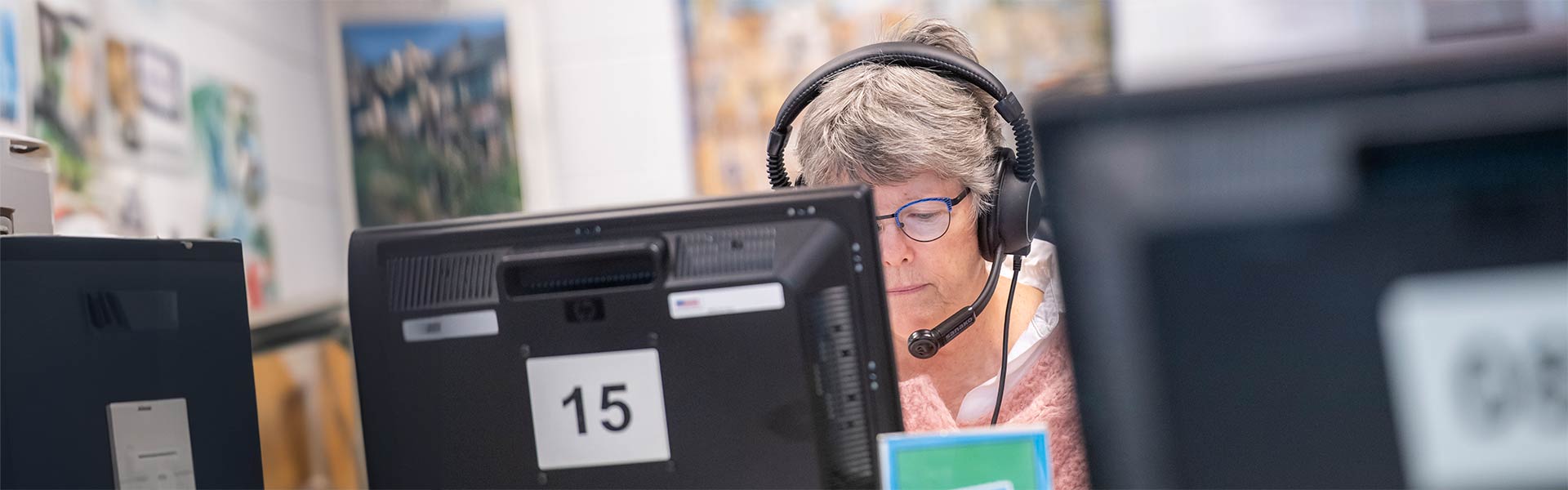 Student with headphones is working on a computer