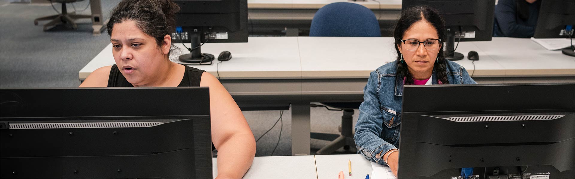 Two students sitting at computers working