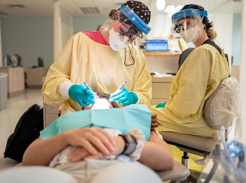 Dental Hygiene students working on a patient.