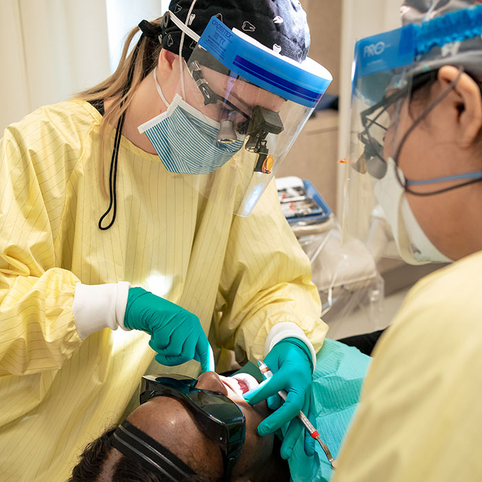 Dental hygiene students providing care to a patient.