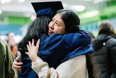 Graduate getting hug from a loved one after commencement