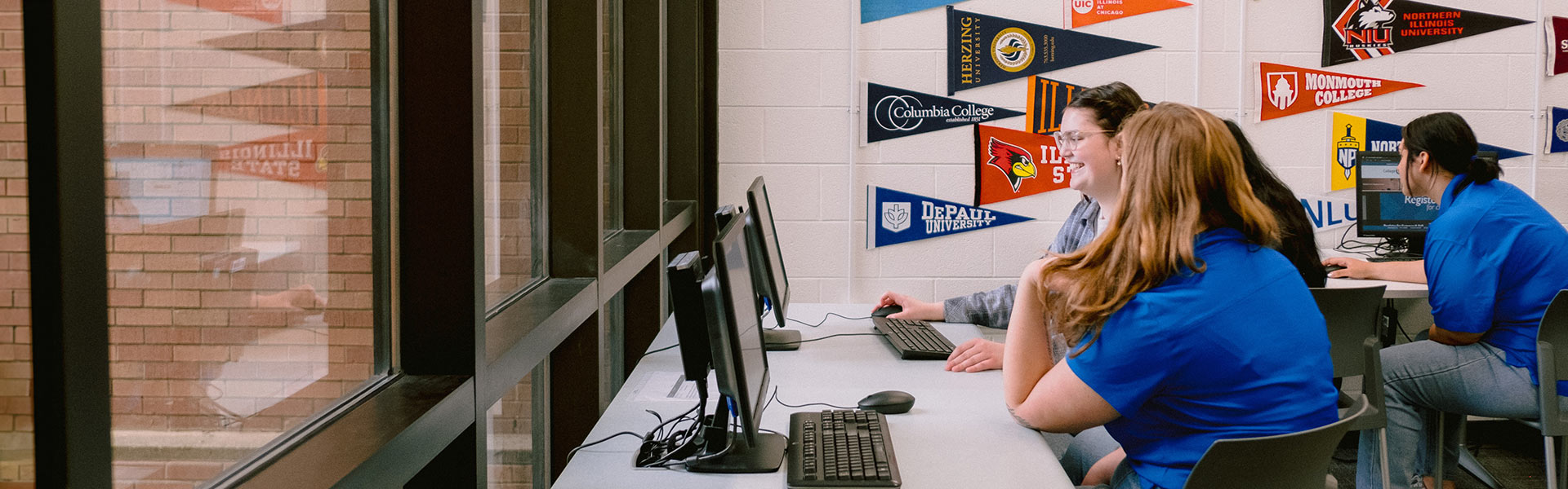 Students in a room with college pennants on the wall