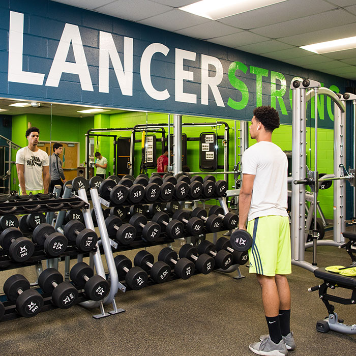 Male student working out with free weights