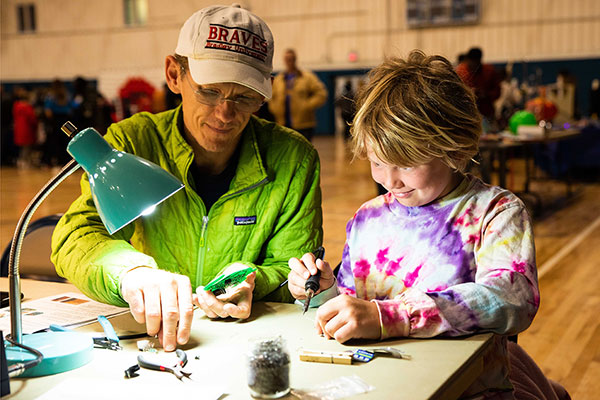 Adult man and child work on soldering project
