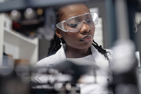 Close-up photo of woman working in manufacturing facility.