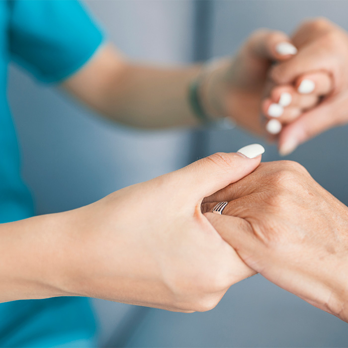 Close up photo of health professional holding patient hands