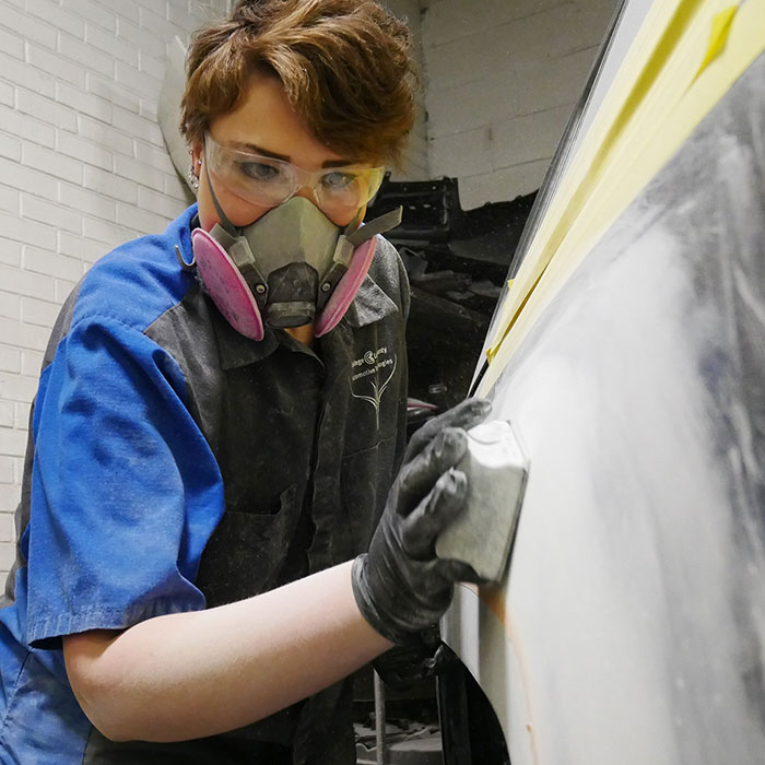 Photo of Olivia Peterson refinishing a vehicle