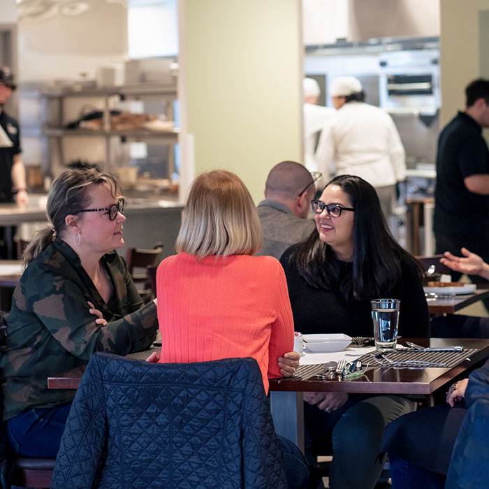 Smiling diners seated around a table at Prairie Restaurant.