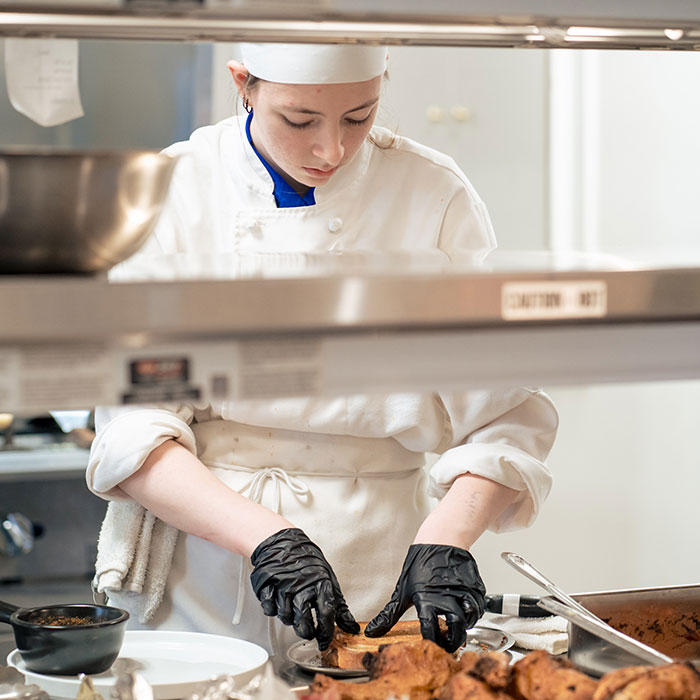 Student practicing back-of-the-house skills at Prairie Restaurant