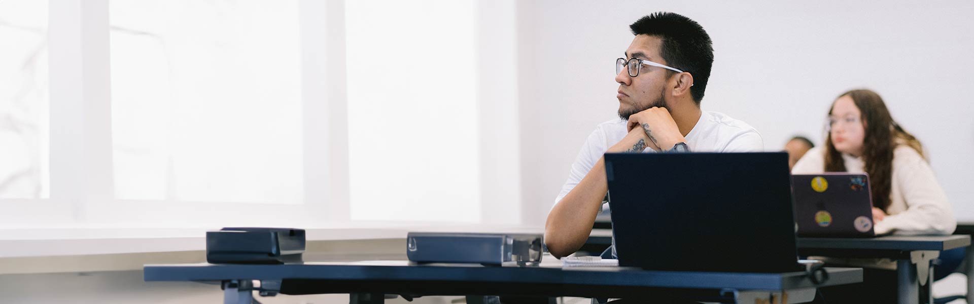 Student sits at desk listening to lecture