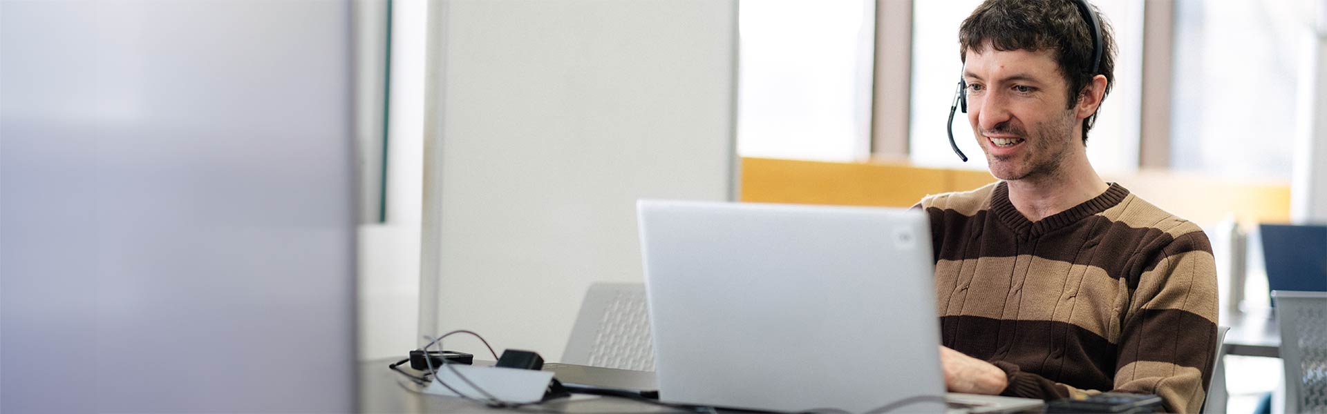 Student with headphones works on laptop