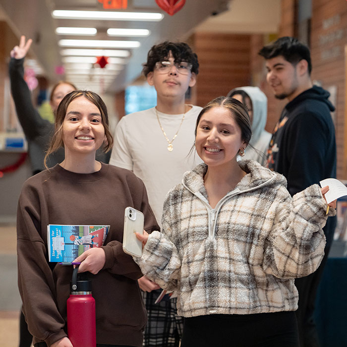 A group of smiling students in the hallway of Southlake Campus