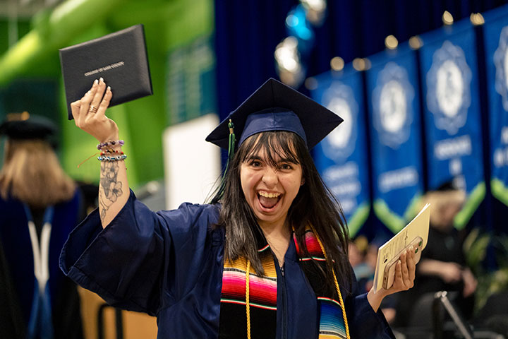 Graduate raising her diploma