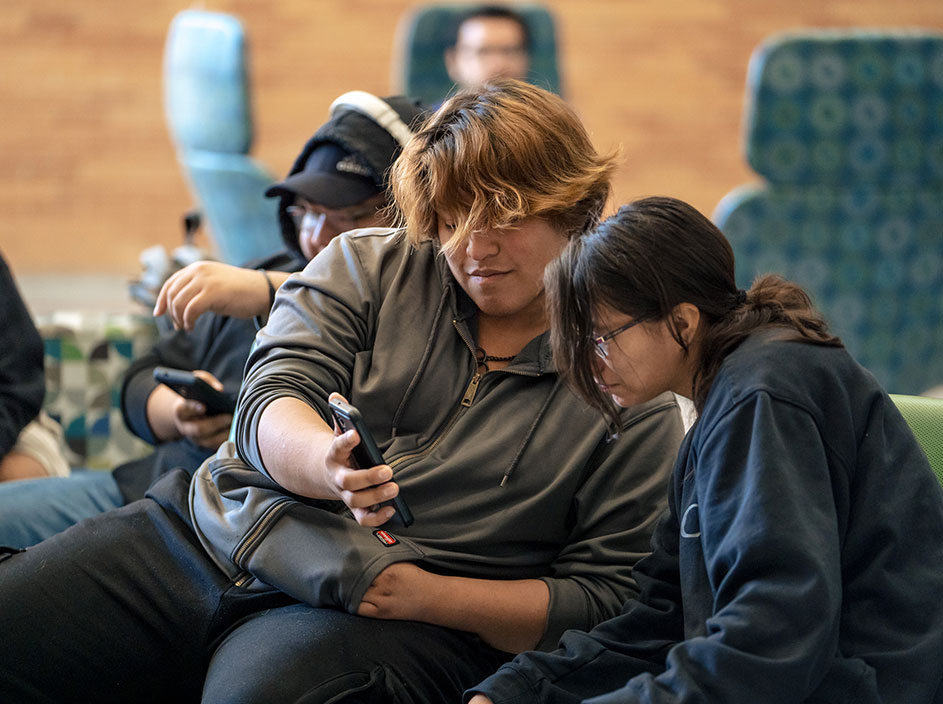 Students looking closely at smartphone