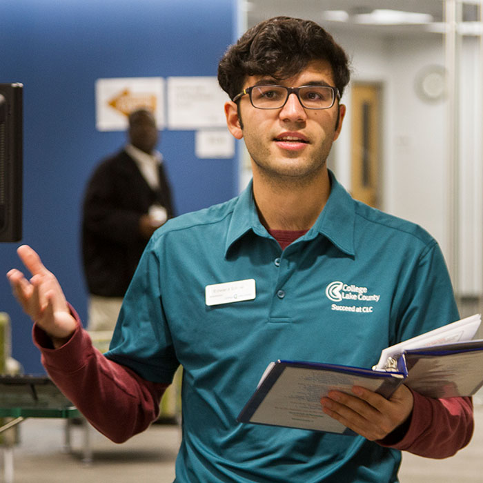 A student ambassador welcomes guests to campus for a tour.