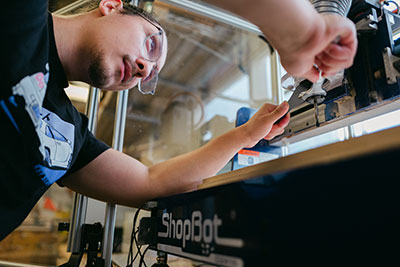 Male student interacting with engineering equipment