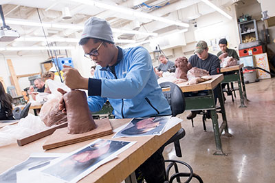 Student making sculpture in studio.
