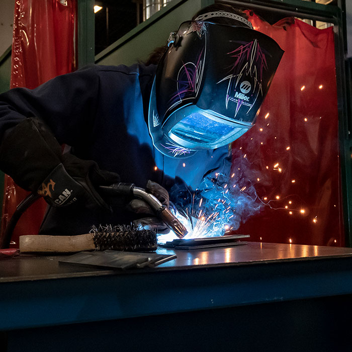 Photo of welder wearing welding helmet while working