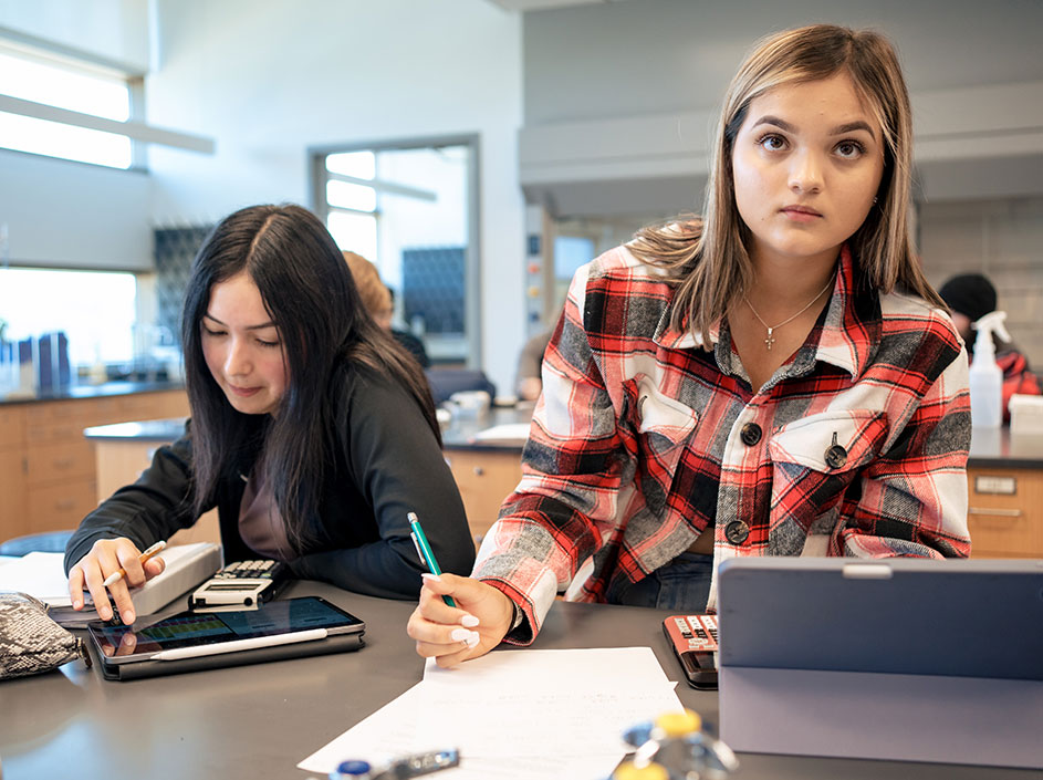 Two female students intently listening in science lab.