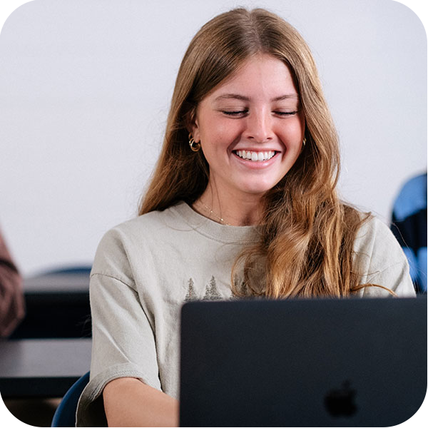 Smiling student sitting at laptop